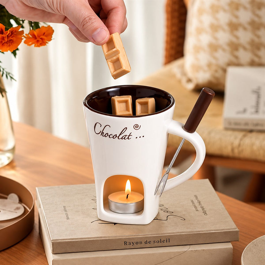 Una mano aggiunge un quadratino di cioccolato nella Chocolight color crema, con la candela accesa nella camera inferiore.
